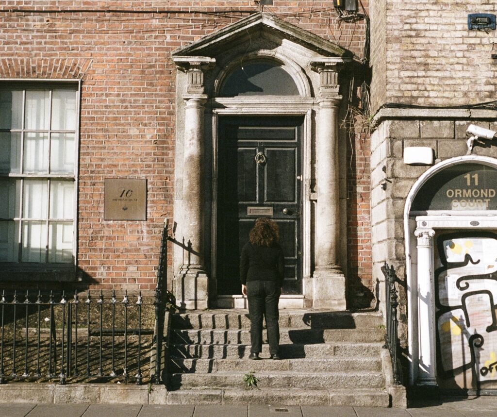 Artist Clodagh Assata Boyce stands outside the door of 10 Ormond Quay.